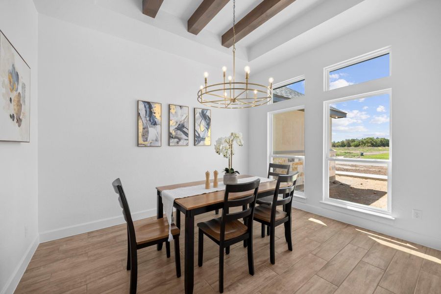 Dining space with hanging lights and light wood finished floors