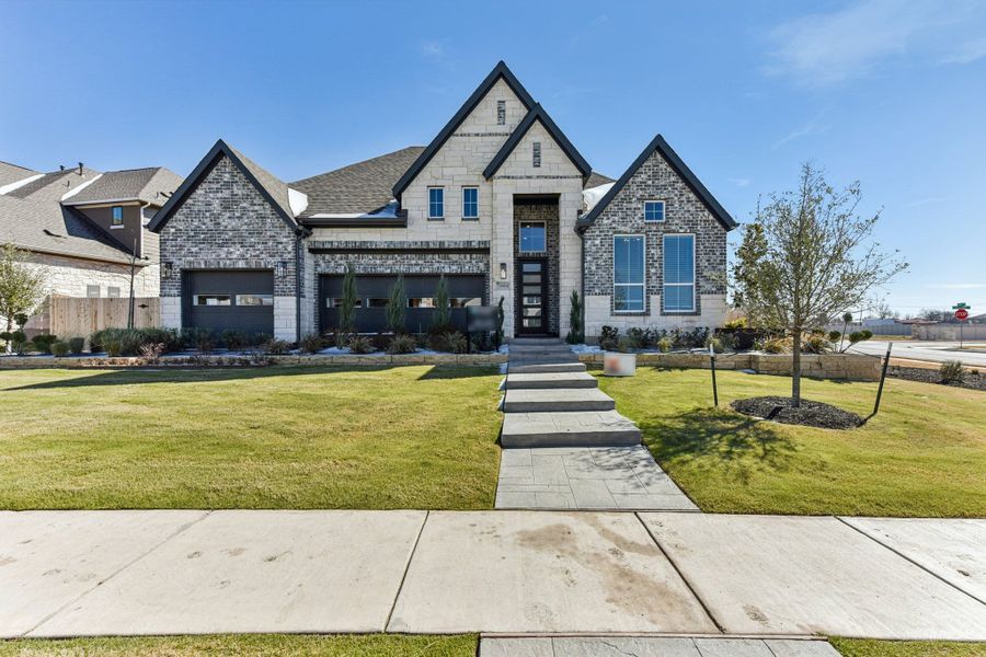 Front exterior of a new home in The Grove at Blackhawk, Pflugerville, TX, highlighting curb appeal (Image 28). Front exterior of a new home in The Grove at Blackhawk, Pflugerville, TX, highlighting curb appeal (Image 28).