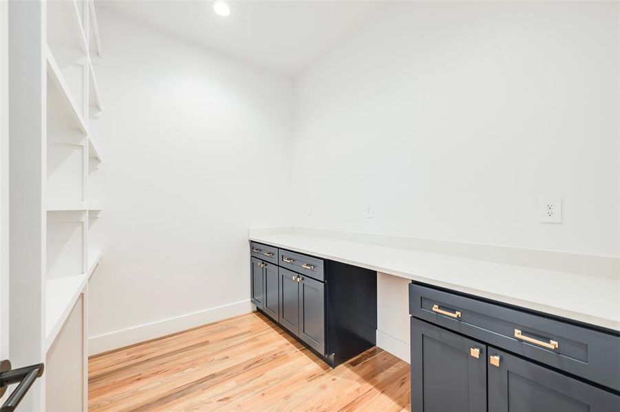 Kitchen featuring light wood-style floors, gray cabinets, recessed lighting, and light stone counters