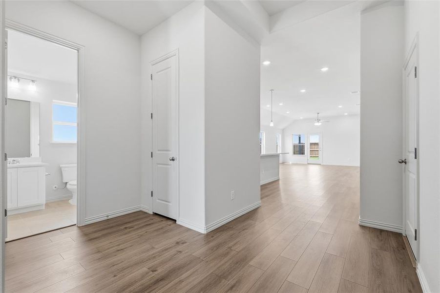 Hallway featuring recessed lighting, light wood-type flooring, and lofted ceiling