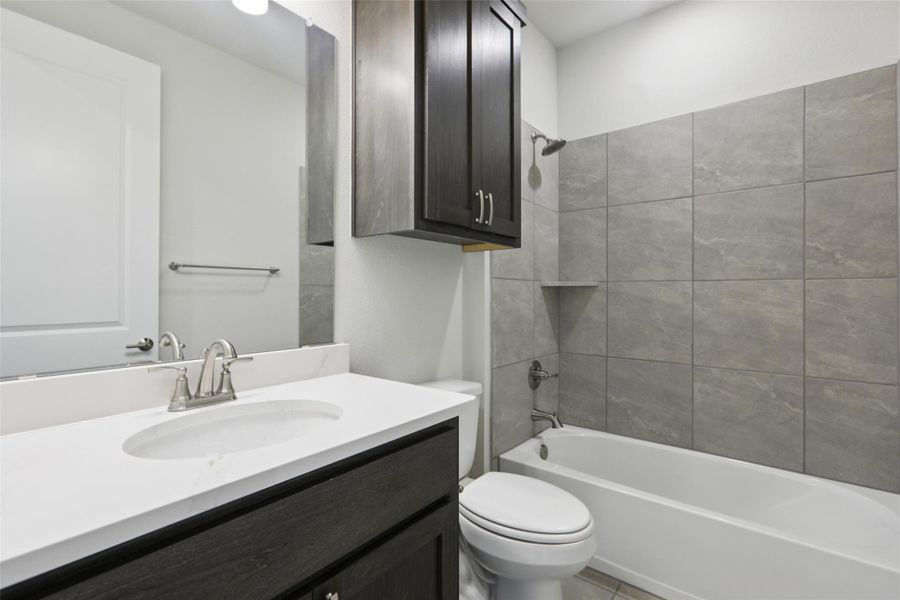 Bathroom featuring washtub / shower combination, vanity, and light tile patterned floors Bathroom featuring washtub / shower combination, vanity, and light tile patterned floors