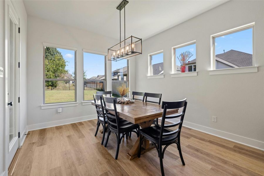 Dining room featuring light wood-type flooring and a chandelier Dining room featuring light wood-type flooring and a chandelier