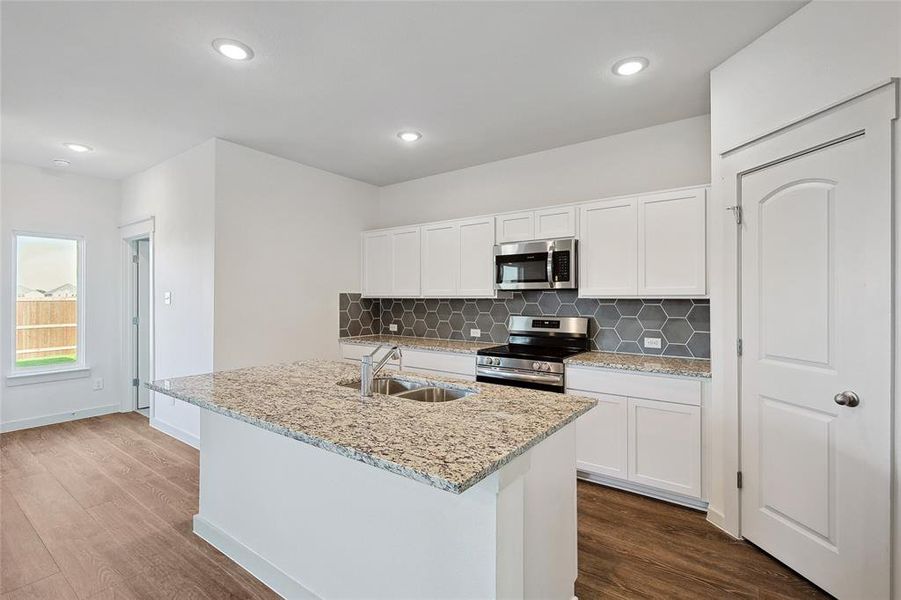 Kitchen featuring stainless steel appliances, sink, dark hardwood / wood-style flooring, and white cabinetry