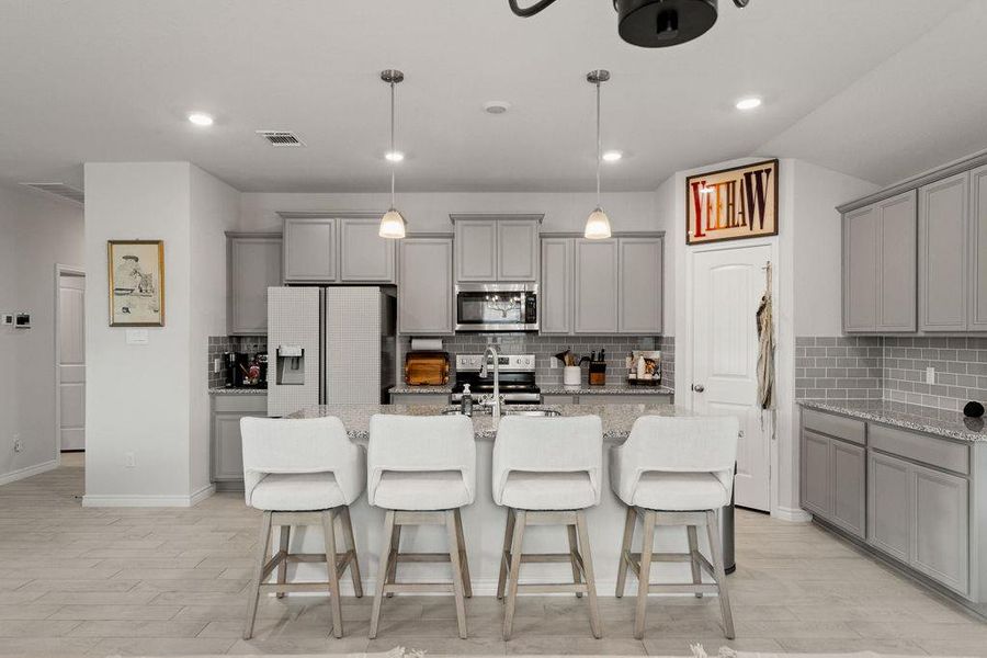 Kitchen featuring gray cabinets, decorative backsplash, and recessed lighting