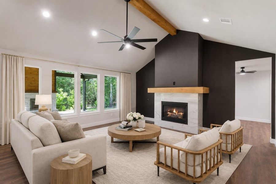 Virtually Staged. Experience the warmth and elegance of this digitally staged living room, featuring a cozy fireplace, stylish wood accents, and abundant natural light through expansive windows, perfect for relaxation and entertaining.