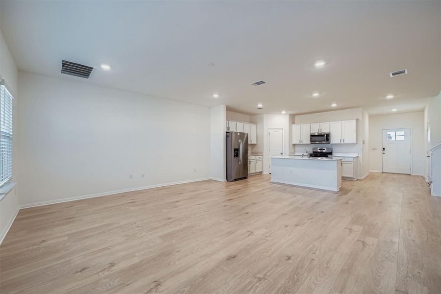 Unfurnished living room with light wood-type flooring and recessed lighting