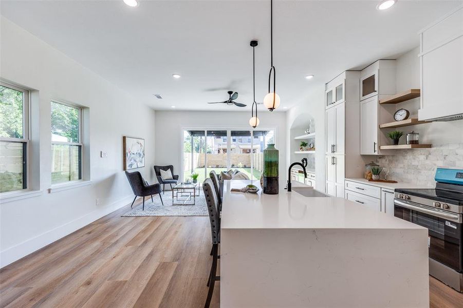 Kitchen featuring electric range, open shelves, light countertops, white cabinets, and light wood-type flooring Kitchen featuring electric range, open shelves, light countertops, white cabinets, and light wood-type flooring