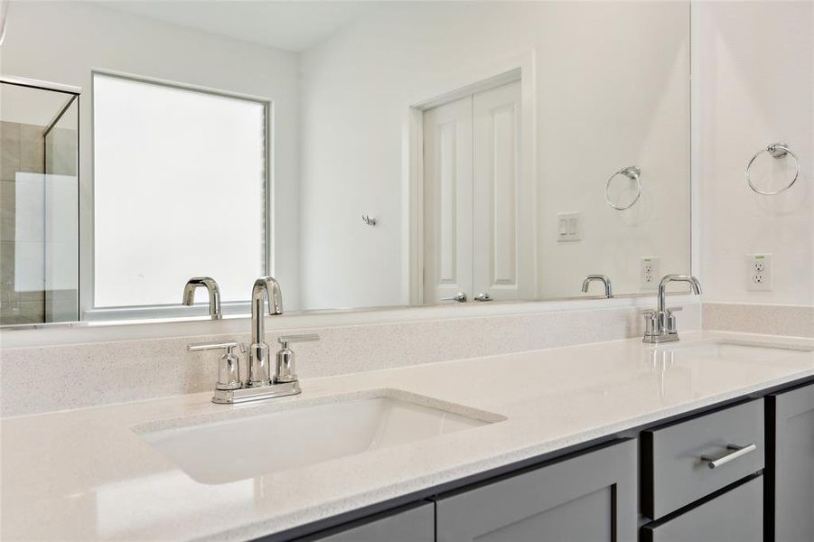 Bathroom featuring vanity, a shower with door, and a wealth of natural light