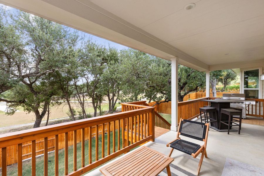 Backyard patio with stained wood railing and stairs leading to the yard