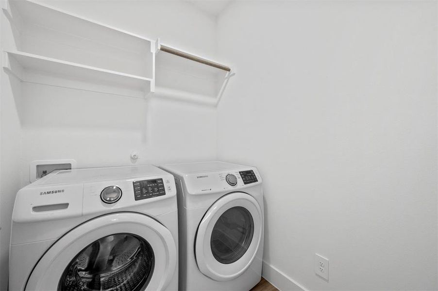 Washroom featuring laundry area, washing machine and dryer, and baseboards