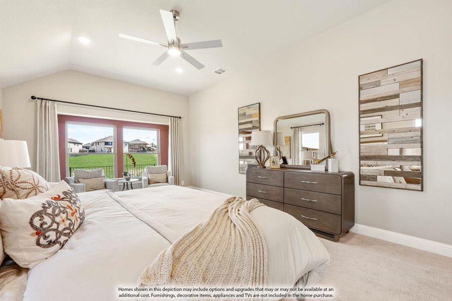 Bedroom with vaulted ceiling, ceiling fan, dresser, and glass doors leading to outdoor seating area