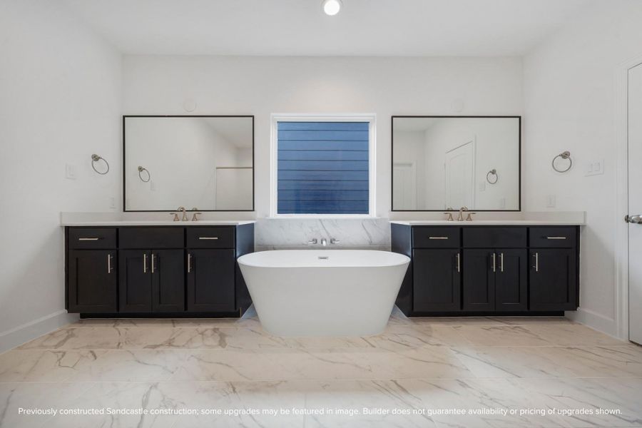 Indulge in daily elegance as you're greeted by the cheerful symmetry of fixtures in your luxuriously styled primary bathroom. Indulge in daily elegance as you're greeted by the cheerful symmetry of fixtures in your luxuriously styled primary bathroom.
