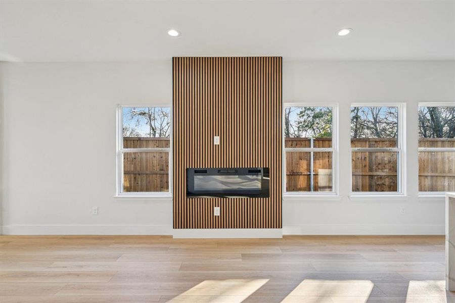 Unfurnished living room with recessed lighting, light wood-style flooring, and healthy amount of natural light