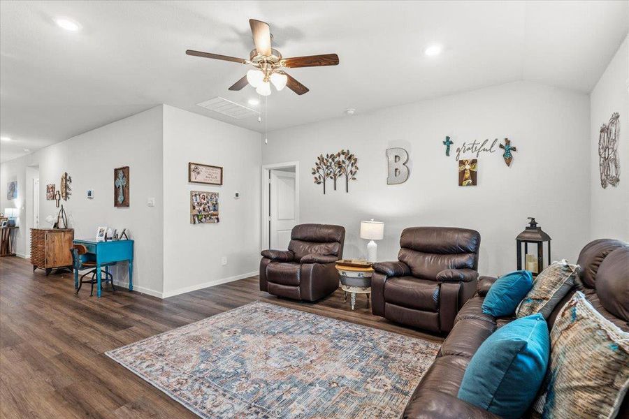 Living area featuring a ceiling fan, dark wood-type flooring, recessed lighting, and vaulted ceiling