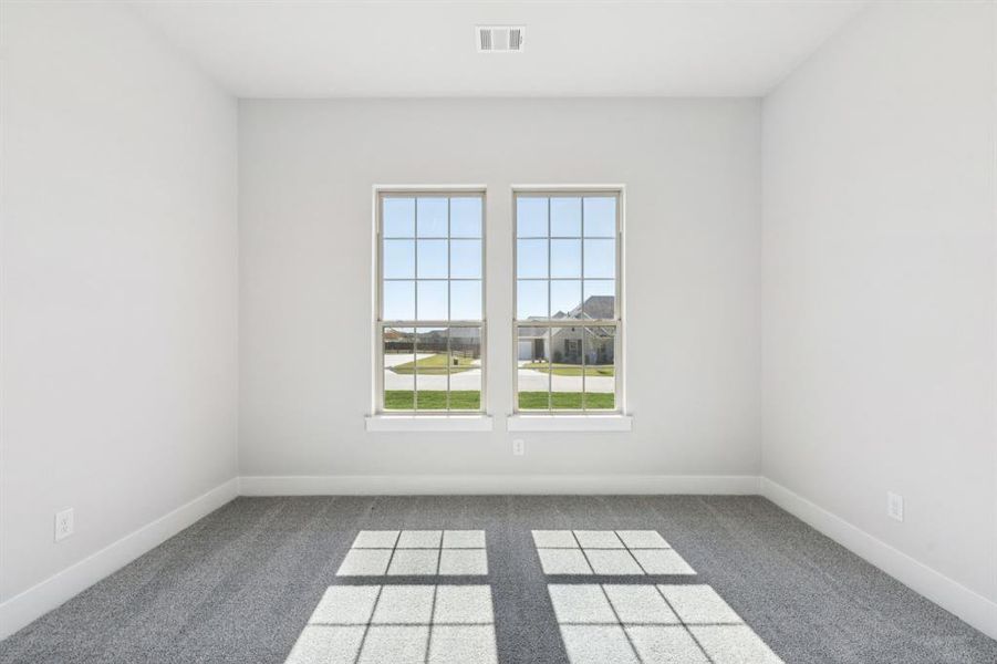 Spare room featuring carpet and baseboards