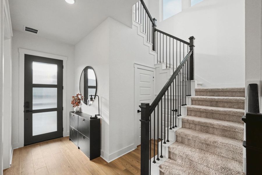 Striking entry showcases soaring ceilings, modern railing accents, and elegant finishes that create an impressive first impression. Abundant natural light and a clean, open design set the tone for the home’s sophisticated style.