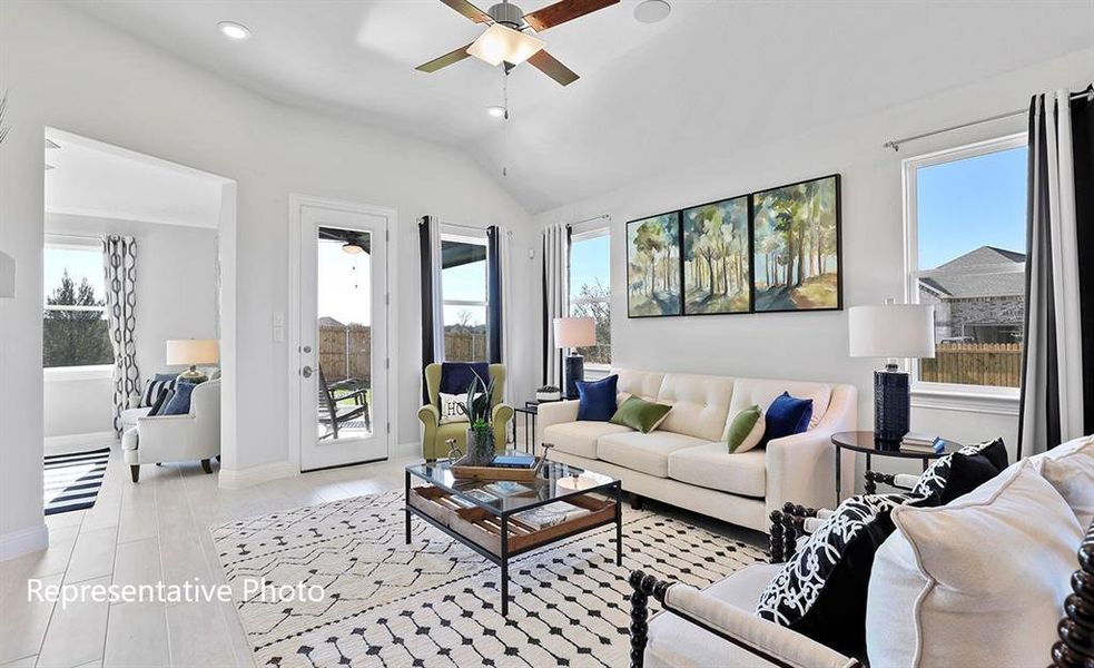 Living area featuring ceiling fan, plenty of natural light, vaulted ceiling, recessed lighting, and light wood-style flooring