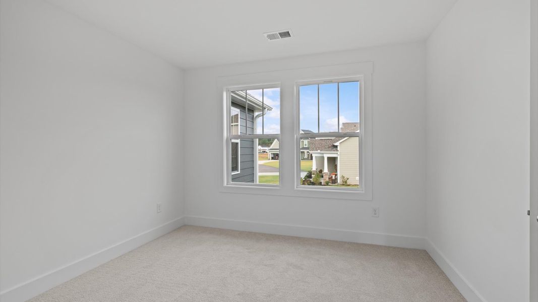 Accomplished design in this restful bedroom featuring plush carpet and oversized window views
