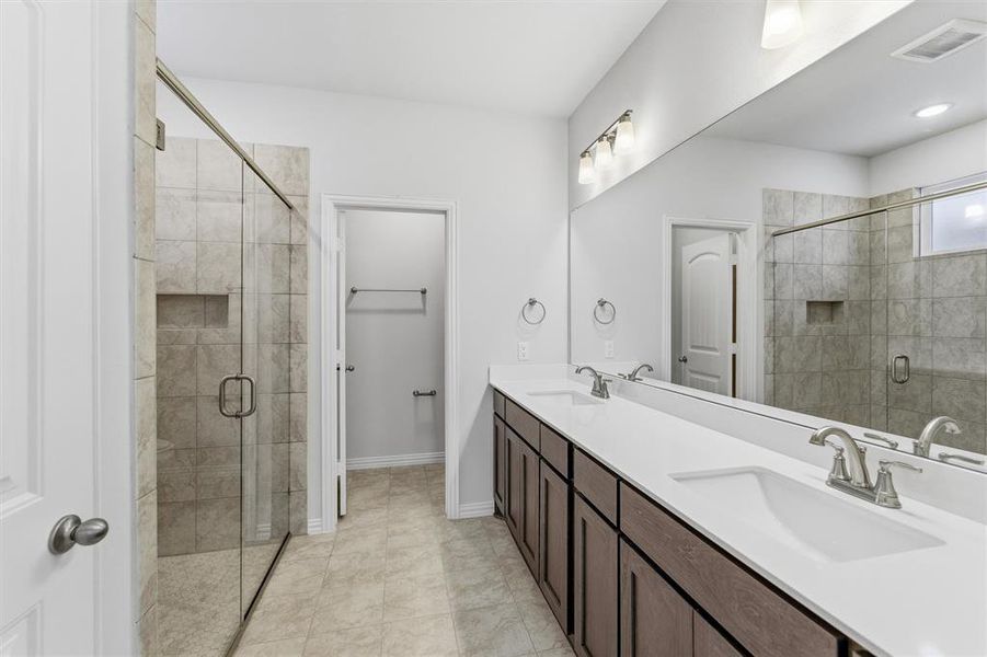Bathroom featuring a shower stall and double vanity Bathroom featuring a shower stall and double vanity
