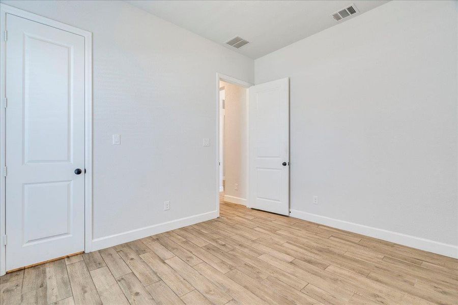 Unfurnished bedroom with baseboards and light wood-style flooring