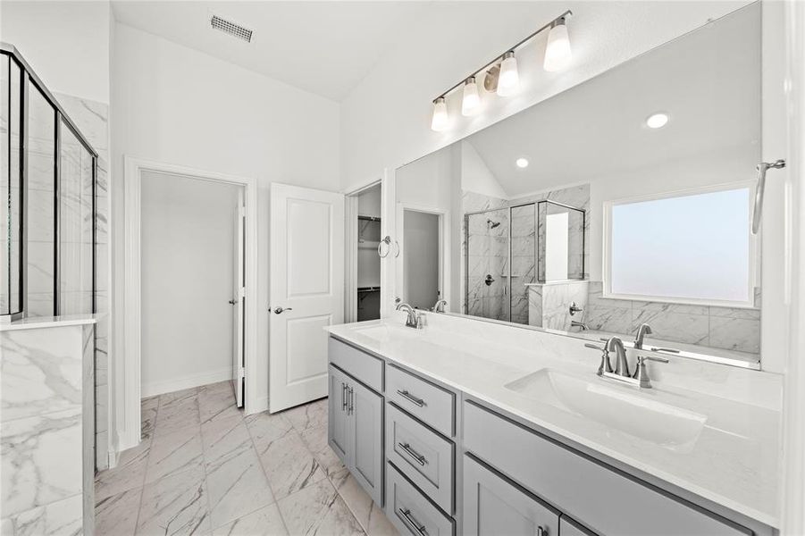 Primary suite bath offers dual vanity, garden tub and separate shower.