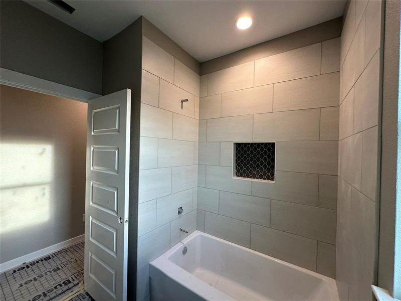 Bathroom featuring tile patterned floors and tiled shower / bath combo