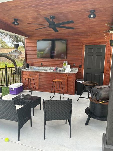 View of patio / terrace with a bar, a ceiling fan, and outdoor lounge area