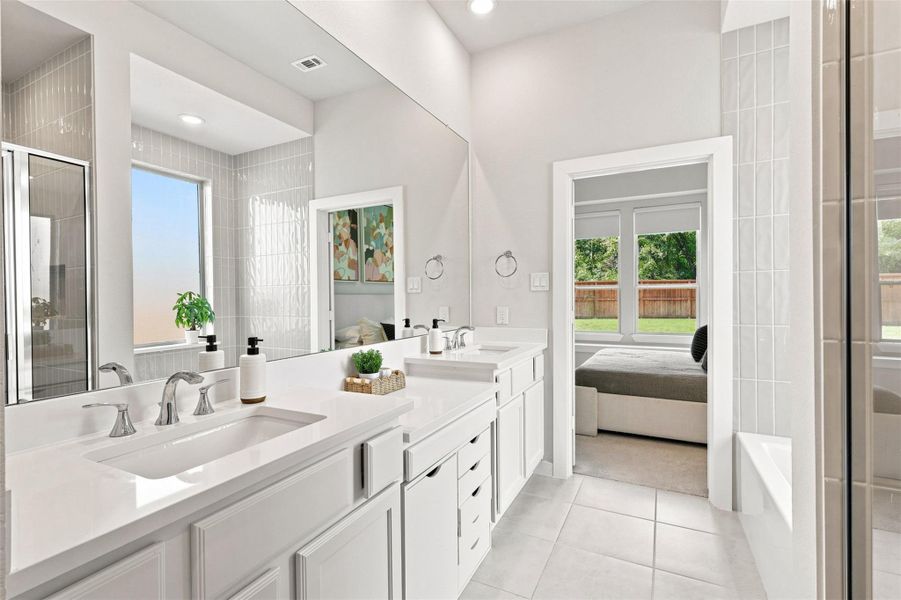 Floor to ceiling tile surround soaking tub/ shower combo. Dual sinks and vanity area currently with removable storage.