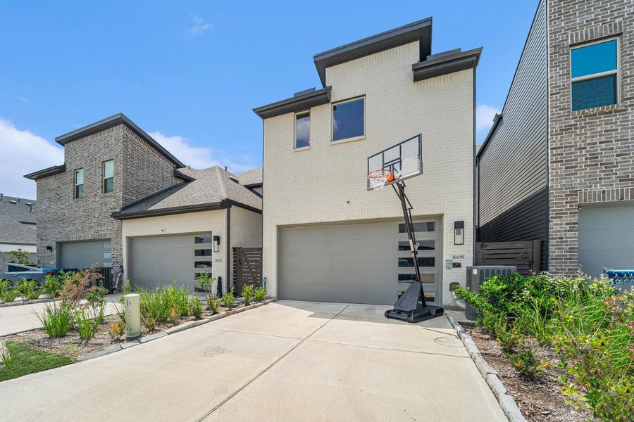 Rear-entry garage with contemporary design and extended driveway.