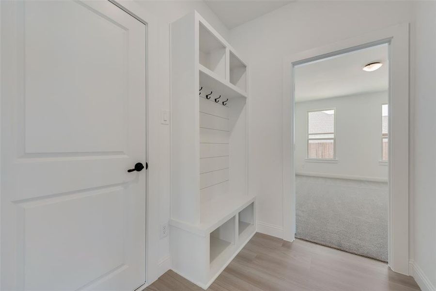 Mudroom featuring light carpet