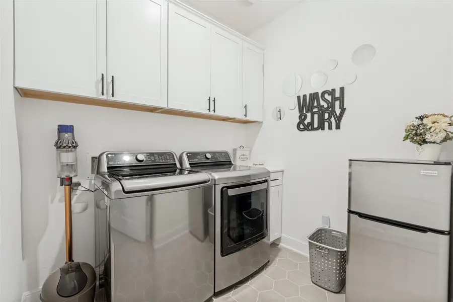 Ample built-in cabinetry and stylish tiled flooring define this functional utility space.