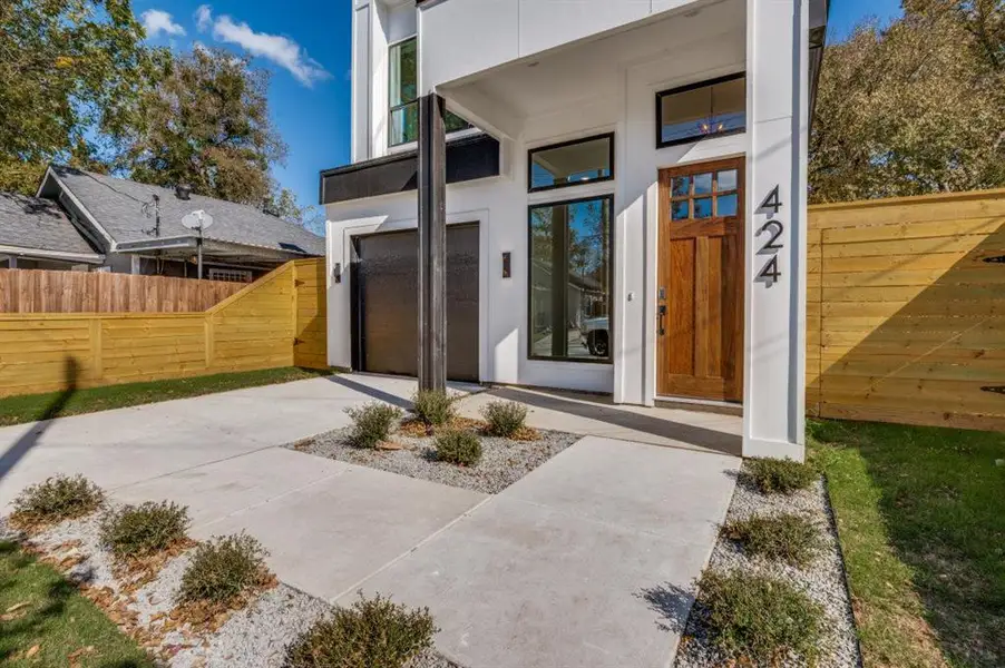 Entrance to property with concrete driveway, a garage, and stucco siding