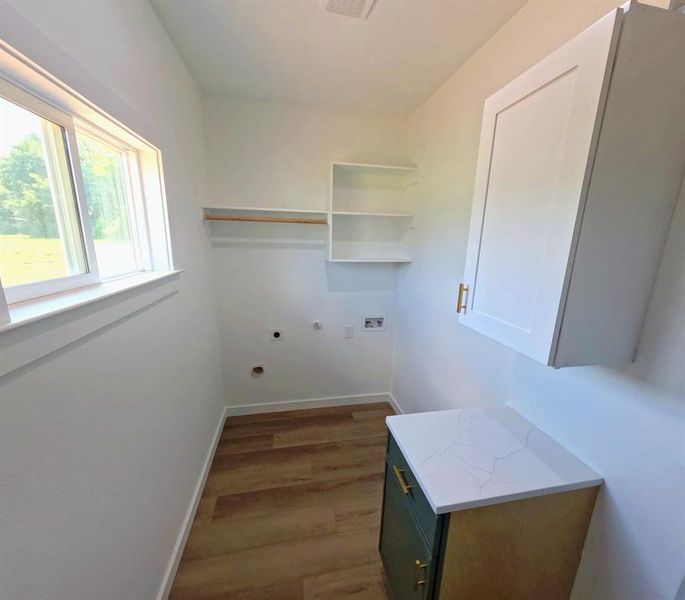 Laundry room with dark wood-type flooring, hookup for an electric dryer, gas dryer hookup, and hookup for a washing machine Laundry room with dark wood-type flooring, hookup for an electric dryer, gas dryer hookup, and hookup for a washing machine