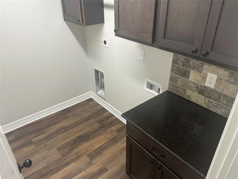 Washroom featuring electric dryer hookup, hookup for a washing machine, cabinet space, and dark wood-type flooring