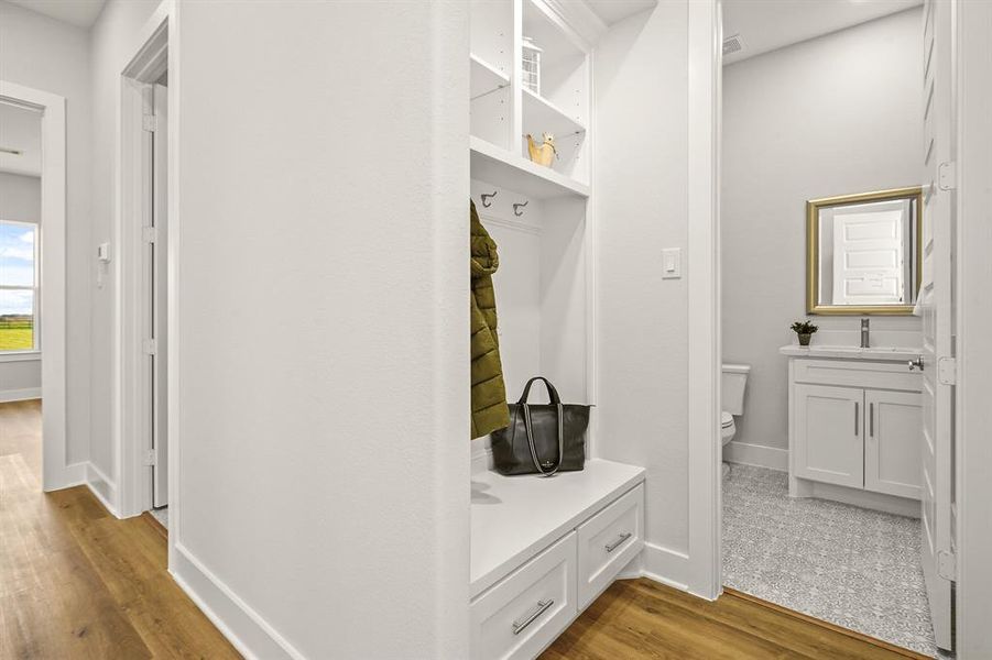 This Mud Room, located right off the 2-car Garage, provides an ideal spot to store keys, backpacks, purses, and jackets. With everything conveniently in one place, losing the keys will be a thing of the past. Notice the Powder Room located straight ahead.