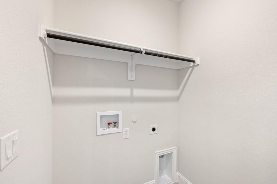 Laundry room with upper shelf, clothing rod, washer hookups, and dryer vent connection on white walls Laundry room with upper shelf, clothing rod, washer hookups, and dryer vent connection on white walls