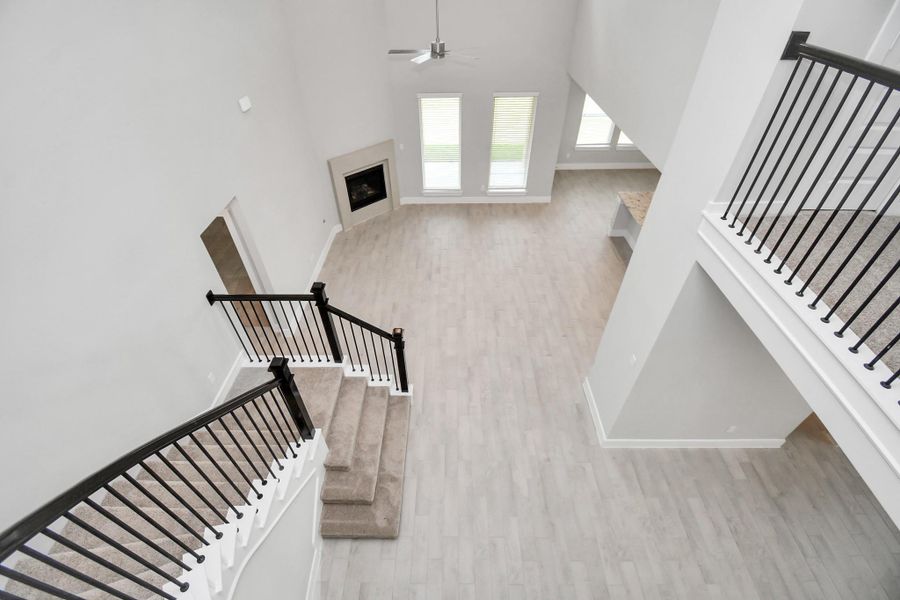 View of family room from landing above. Sample photo of completed home with similar floor plan. Actual colors and selections may vary.