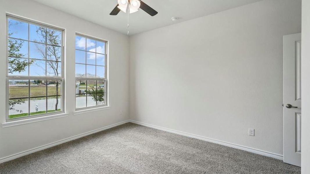 Empty room with ceiling fan and carpet floors