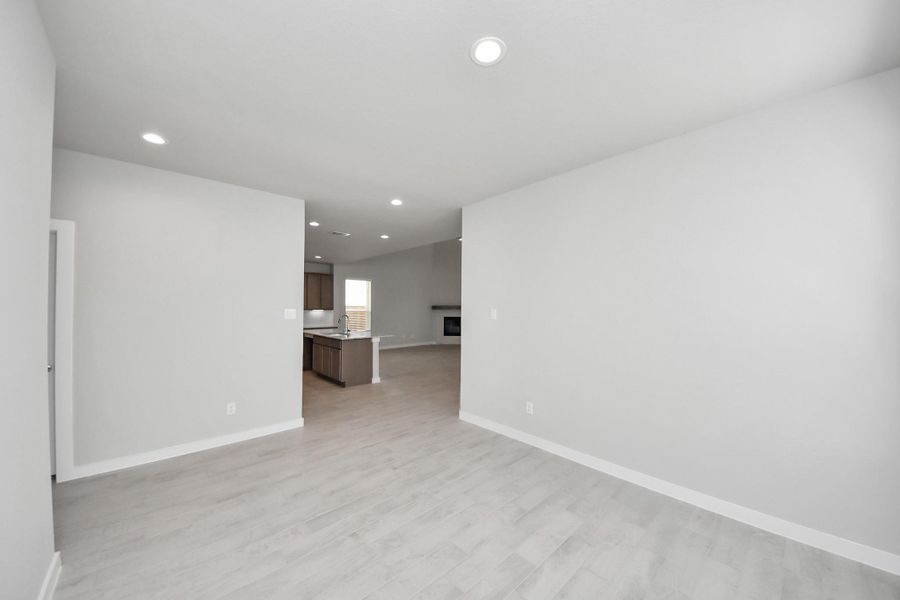 Make memories gathered around the table with your family and friends! This spacious dining room features elegant flooring, custom paint, and adjacent to family room and kitchen for open concept feel. Sample photo of completed home with similar floor plan. Actual colors and selections may vary.