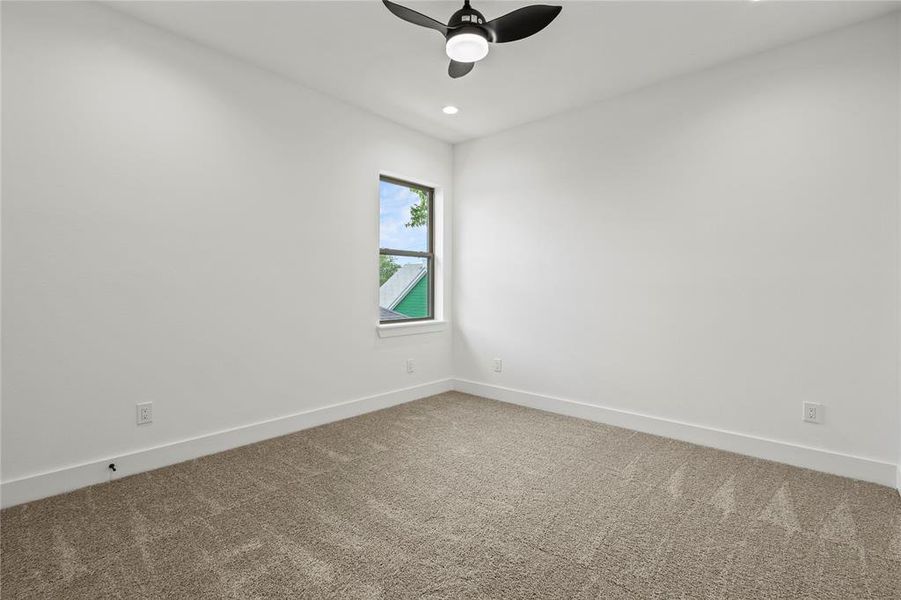 Carpeted spare room featuring ceiling fan