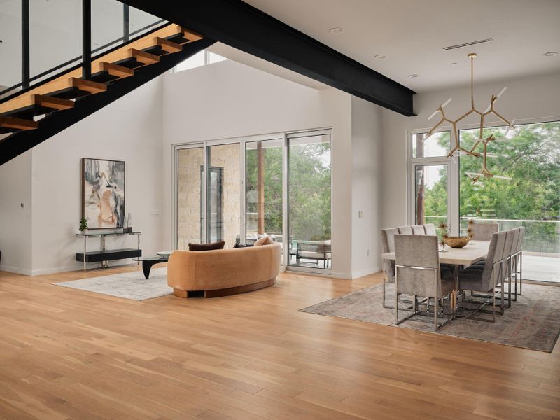 An open floorplan with high ceilings and extensive natural light creates an inviting living and dining space. An open floorplan with high ceilings and extensive natural light creates an inviting living and dining space.