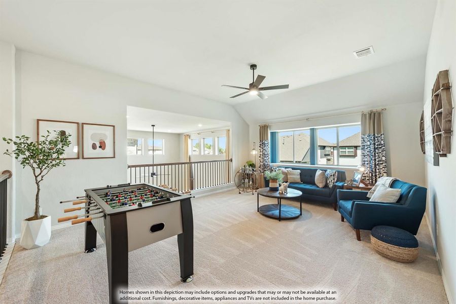Upstairs game room with foosball table, blue sofas, ceiling fan, and open loft railing overlooking lower level Upstairs game room with foosball table, blue sofas, ceiling fan, and open loft railing overlooking lower level
