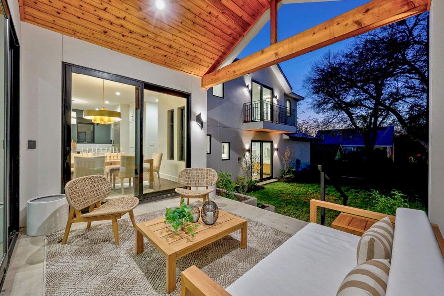 Covered patio with a natural wood plank ceiling, exposed wood beams, and a concrete floor