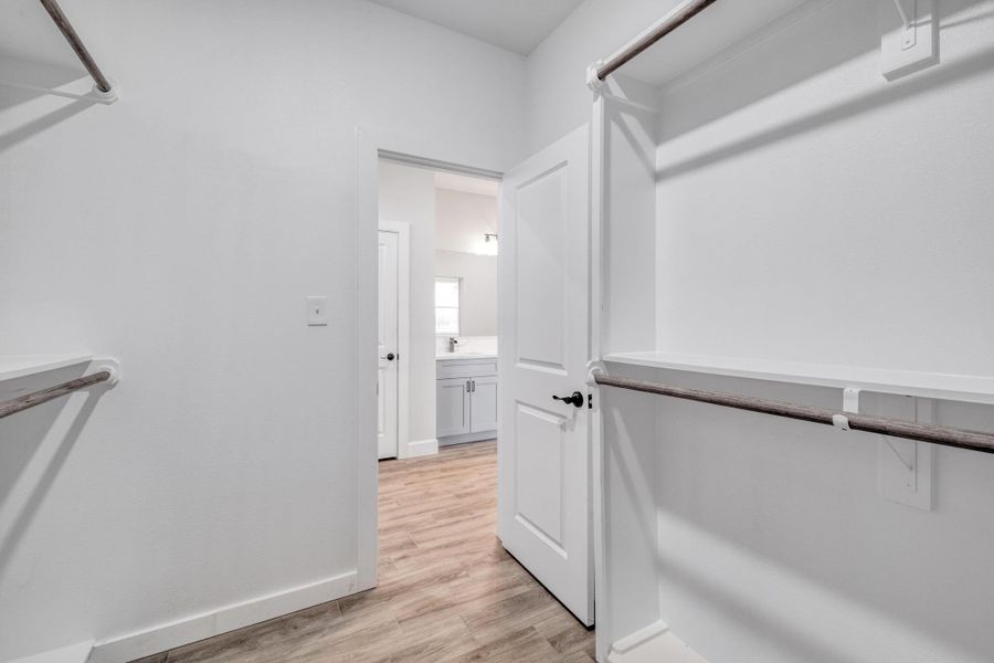 Spacious closet with light wood-type flooring and a sink