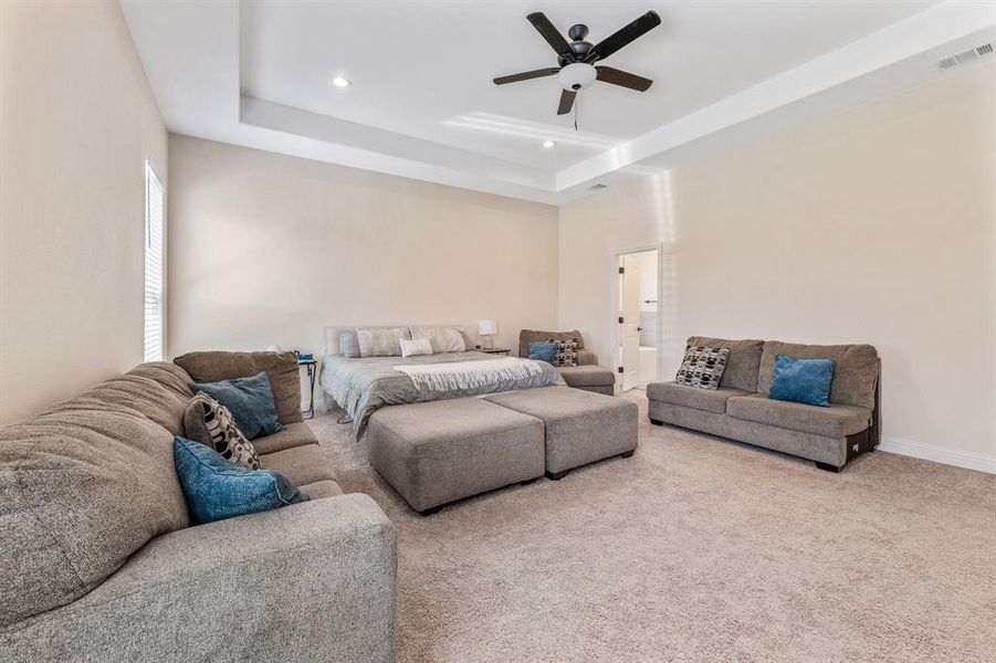 Living room featuring a tray ceiling, carpet floors, ceiling fan, and recessed lighting Living room featuring a tray ceiling, carpet floors, ceiling fan, and recessed lighting