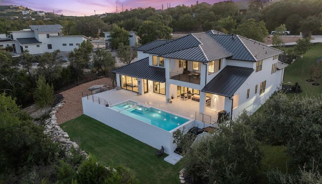 Modern architectural residence featuring a white stucco exterior and dark metal roofing