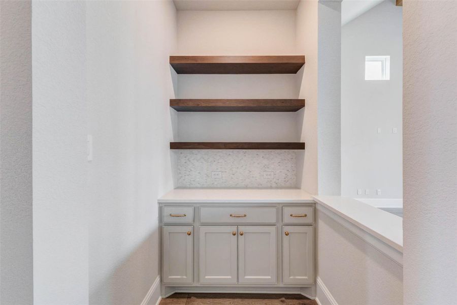 Beautiful coffee or cocktail nook with built-in cabinetry and floating wood shelves.