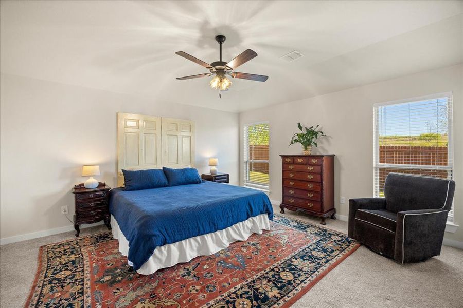 Bedroom with light carpet and a ceiling fan