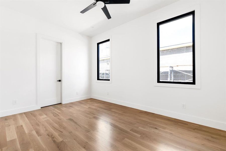 Unfurnished room with light wood finished floors and a ceiling fan Unfurnished room with light wood finished floors and a ceiling fan