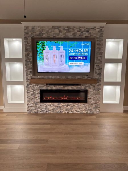 beautiful fireplace/tv wall with lighting